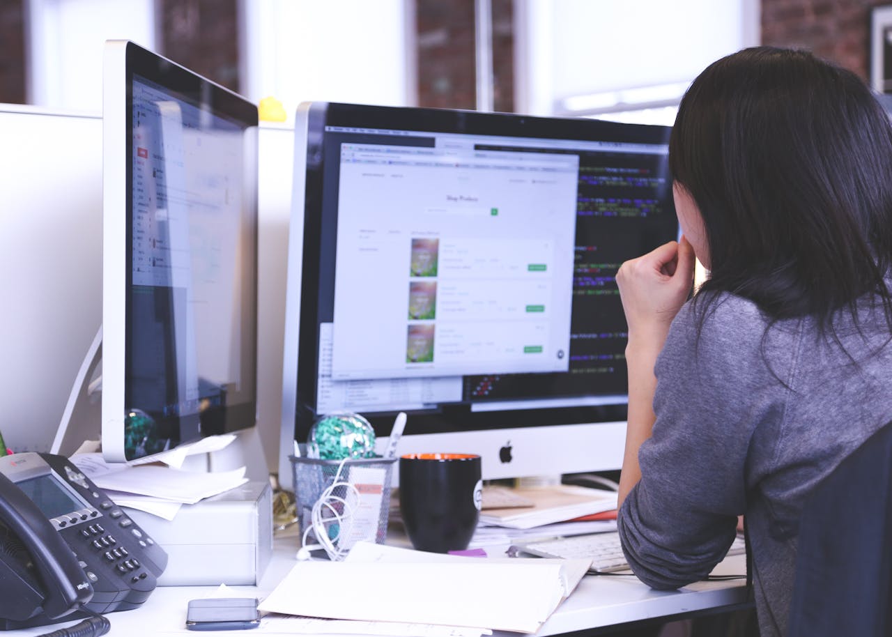 The Art of Drawing Readers In: Your attractive post title goes here Professional woman focused on work using dual monitors in a modern office.